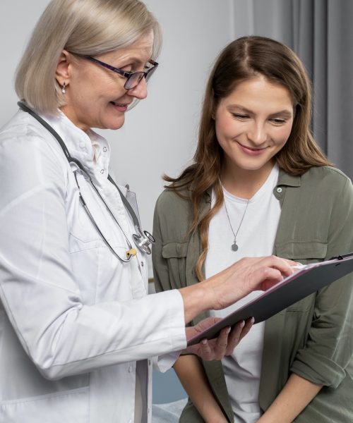 doctor talking to patient while looking at clip board